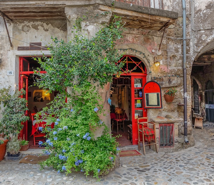 Calcata, Lazio, Italy - September 9, 2017: Small local two-door red with a vine between the two doors, License Type: media, Download Time: 2024-10-10T20:09:37.000Z, User: tasminwaby56, Editorial: true, purchase_order: 65050, job: Online Editorial, client: Rome day trips, other: Tasmin Waby